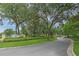 View of a landscaped community entrance with mature trees and signage at 6332 Timberly Ln, Zephyrhills, FL 33542