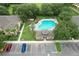 Aerial view of the community pool with a lounge area, palm trees, and clubhouse at 6332 Timberly Ln, Zephyrhills, FL 33542