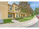Well-maintained townhome featuring manicured lawns, mature trees, and a welcoming entryway at 6332 Timberly Ln, Zephyrhills, FL 33542