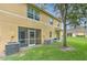 Exterior view of a two-story home, with a screened patio, lush lawn, and large shade tree at 6332 Timberly Ln, Zephyrhills, FL 33542