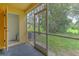 View of a screened patio with an open door, overlooking a lush green lawn at 6332 Timberly Ln, Zephyrhills, FL 33542