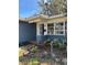 View of the home's entry showing a white framed window and nicely landscaped garden bed at 641 Geneva Pl, Tampa, FL 33606