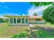 Home exterior featuring a screened in porch, small yard, and traditional design with a red roof and trim at 8402 Roxboro Dr, Hudson, FL 34667