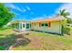 Home exterior featuring a sunroom, small yard, and traditional design with a red roof and trim at 8402 Roxboro Dr, Hudson, FL 34667