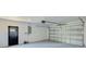 Spacious garage with an automatic door opener, utility door and electrical panel, providing ample storage and workspace at 8402 Roxboro Dr, Hudson, FL 34667