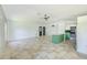Open kitchen featuring an island with light countertops, green cabinets, and tile flooring at 8402 Roxboro Dr, Hudson, FL 34667