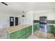 Well-lit kitchen featuring green cabinets, stainless steel appliances, and light countertops at 8402 Roxboro Dr, Hudson, FL 34667