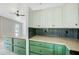 Well-lit kitchen showcasing green lower cabinets and white upper cabinets with light countertops at 8402 Roxboro Dr, Hudson, FL 34667