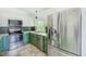 A kitchen featuring green lower cabinets and modern stainless steel appliances at 8402 Roxboro Dr, Hudson, FL 34667