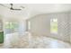 Open-concept living space featuring neutral tile floors and a decorative accent wall with sliding glass door at 8402 Roxboro Dr, Hudson, FL 34667