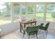 Bright sunroom setup as an office with a wooden desk, comfortable chairs, and picturesque views through large windows at 8402 Roxboro Dr, Hudson, FL 34667