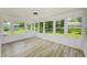 Bright sunroom with new floors and multiple windows offering great natural light and views of the landscaped yard at 8402 Roxboro Dr, Hudson, FL 34667