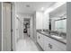 Elegant bathroom featuring dual sinks with granite counters and modern fixtures, complemented by a walk-in closet at 10270 Shady Preserve Dr, Riverview, FL 33578