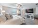 Relaxing main bedroom featuring a ceiling fan, fireplace, TV, and soft, neutral tones at 10270 Shady Preserve Dr, Riverview, FL 33578