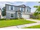 Attractive two-story home with a lush green lawn, a two-car garage, and a well-manicured garden at 10270 Shady Preserve Dr, Riverview, FL 33578