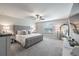 Serene main bedroom with a tufted headboard, ceiling fan, and ample natural light at 10270 Shady Preserve Dr, Riverview, FL 33578