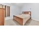 Cozy bedroom with neutral walls, wood bedframe, plush carpeting, and a large window at 10813 Rockledge View Dr., Riverview, FL 33579