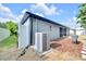 House exterior featuring the AC unit, siding, and a glimpse of the backyard and landscaping at 10813 Rockledge View Dr., Riverview, FL 33579