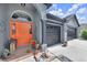 Welcoming entrance with a vibrant orange door, stone accents, and a well-kept two-car garage at 10813 Rockledge View Dr., Riverview, FL 33579