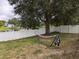 View of backyard showing a hammock near the lake and a white vinyl fence at 12216 Southbridge Ter, Hudson, FL 34669