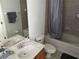 Bathroom featuring a single vanity sink, toilet, shower-tub combo, neutral tile, and mirrored wall at 12216 Southbridge Ter, Hudson, FL 34669