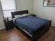 Bedroom with a dark sleigh bed, matching nightstands, wood floors, and bright natural light from a window at 12216 Southbridge Ter, Hudson, FL 34669