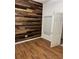 Bedroom with hardwood flooring, accent wall, and natural light through window at 12216 Southbridge Ter, Hudson, FL 34669