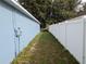 Side view of the home showing a white vinyl fence and side yard at 12216 Southbridge Ter, Hudson, FL 34669