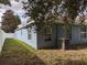 Side view of the blue home with lush green lawn and white vinyl fence at 12216 Southbridge Ter, Hudson, FL 34669