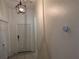 Hallway with neutral walls, tiled floors, featuring modern lighting and digital thermostat at 12216 Southbridge Ter, Hudson, FL 34669