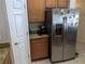 View of kitchen appliances including stainless steel refrigerator and oak cabinets at 12216 Southbridge Ter, Hudson, FL 34669