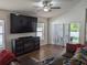 Bright living room with wood floors, large windows, ceiling fan, and sliding glass door at 12216 Southbridge Ter, Hudson, FL 34669