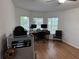 Well-lit office space featuring wood floors, multiple monitors, and a large desk with computer equipment at 12216 Southbridge Ter, Hudson, FL 34669