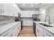 Bright kitchen with white cabinets, stainless steel appliances, stone backsplash, and wood-look flooring at 12910 Prestwick Dr, Riverview, FL 33579