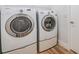 Featuring side-by-side, front-load, white Samsung washer and dryer set in the laundry room at 12910 Prestwick Dr, Riverview, FL 33579