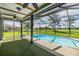 Screened-in pool area overlooking a vast lawn, perfect for outdoor relaxation and entertainment at 12910 Prestwick Dr, Riverview, FL 33579