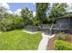 Landscaped backyard with a modern hot tub and spacious deck perfect for outdoor gatherings at 1600 Lonesome Pine Ln, Tarpon Springs, FL 34689