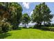 Scenic backyard with lush lawn, mature trees and lake access at 1600 Lonesome Pine Ln, Tarpon Springs, FL 34689