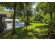 Spacious backyard with lush green grass and mature trees creating a private oasis at 1600 Lonesome Pine Ln, Tarpon Springs, FL 34689