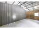 Spacious metal barn interior featuring a concrete floor and simple lighting fixture at 1600 Lonesome Pine Ln, Tarpon Springs, FL 34689