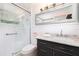 Updated bathroom features a glass enclosed shower, tiled walls, and vanity with a marble countertop at 1600 Lonesome Pine Ln, Tarpon Springs, FL 34689