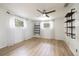 Bright bedroom with hardwood floors, ceiling fan, modern curtains, and floating shelves at 1600 Lonesome Pine Ln, Tarpon Springs, FL 34689