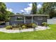 Charming single-story home with lush landscaping, a well-manicured lawn, and a welcoming front entrance at 1600 Lonesome Pine Ln, Tarpon Springs, FL 34689
