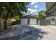 Detached two-car garage next to main house, featuring painted metal siding and white garage doors at 1600 Lonesome Pine Ln, Tarpon Springs, FL 34689