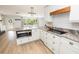Open-concept kitchen with white cabinets, stainless appliances, and a large island at 1600 Lonesome Pine Ln, Tarpon Springs, FL 34689