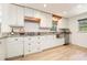 Renovated kitchen with granite counters, stainless appliances, white subway tile backsplash, and white cabinets at 1600 Lonesome Pine Ln, Tarpon Springs, FL 34689
