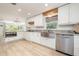 Modern kitchen featuring stainless steel appliances, white cabinets, and granite countertops at 1600 Lonesome Pine Ln, Tarpon Springs, FL 34689