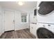 Laundry room with stainless steel sink and stacked washer and dryer next to exterior door at 1600 Lonesome Pine Ln, Tarpon Springs, FL 34689