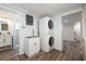 Well-lit laundry room with stainless steel sink, stacked washer/dryer, and access to bath at 1600 Lonesome Pine Ln, Tarpon Springs, FL 34689