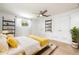 This staged main bedroom includes wood-look floors, a ceiling fan, wall mounted shelves, and closet storage at 1600 Lonesome Pine Ln, Tarpon Springs, FL 34689